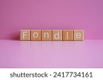 Small photo of Wooden blocks form the text "Fondle" against a pink background.