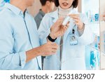 Small photo of Closeup professional pharmacist advise or explain property of qualified medical product to customer in pharmacy, druggist answer to client healthcare inquiry, medical service and consultation concept.