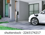 Progressive concept of EV car and home charging station powered by sustainable and clean energy with zero CO2 emission for green environmental. Charging point at residential area for electric vehicle.