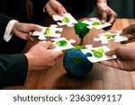 Small photo of Cohesive group of business people holding eco icon jigsaw puzzle pieces around globe Earth as eco corporate responsibility for community and sustainable solution for greener Earth. Quaint