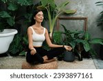 Small photo of Young woman doing morning yoga and meditation in natural garden with plant leaf, enjoying the solitude and practicing meditative poses. Mindfulness activity and healthy mind lifestyle. Blithe