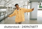 Small photo of Closeup of skilled hipster listen music from headphone while moving hand. Professional break dancer perform freestyle footstep while walking and looking at camera. Outdoor sport 2024. Sprightly.