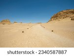 Landscape scenic view of desolate barren western desert in Egypt with footpath through geological mountain sandstone rock formations