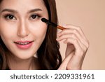 Small photo of Closeup ardent young woman with healthy fair skin applying her eyeshadow with brush. Female model with fashion makeup. Beauty and makeup concept.