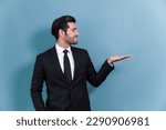 Small photo of Confident businessman in formal suit making holding hand gesture to indicate promotion or advertising on empty space with excited facial expression and gesture on isolated background. Fervent