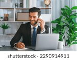 Small photo of Diligent businessman busy talking on the phone call with clients while working with laptop in his office as concept of modern hardworking office worker lifestyle with mobile phone. Fervent