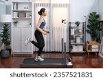 Small photo of Full length side view of energetic and strong athletic asian woman running running machine at home. Pursuit of fit physique and commitment to healthy lifestyle with home workout and training. Vigorous