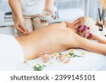 Small photo of Woman customer having exfoliation treatment in luxury spa salon with warmth candle light ambient. Salt scrub beauty treatment in health spa body scrub. Quiescent