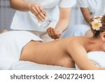 Small photo of Masseur hands pouring aroma oil on couple's back. Masseuse prepare oil massage procedure for customer at spa salon in luxury resort. Aroma oil body massage therapy concept. Quiescent