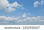 Small photo of Beautiful white cumulus clouds adorn the blue sky on a sunny day, foreshadowing an impending storm with their majestic presence