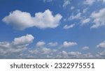 Small photo of Beautiful white cumulus clouds adorn the blue sky on a sunny day, foreshadowing an impending storm with their majestic presence