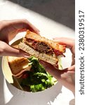 Small photo of Woman's hand with meatball toast with cheese on white background. Delicious toast with meatballs and salad. Woman hand holding delicious toast, sandwich. Meat sandwich. Toast with meat.