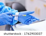 Small photo of Dentist holding in her dentist's hand carpool syringe for local anaesthesia