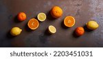 Small photo of Beautiful citrus lemon orange top view arrangement on warm, grunge, rusted background in contrasted light, with complimentary blue hues.