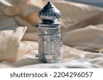 Small photo of A sefer torah small Torah scrolls A silver antique with a tour of the tablets of the covenant with the Hebrew letters. placed on a tallit