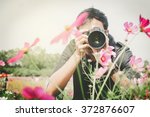 man photographer taking photos of flowers