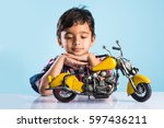 Indian small kid playing or repairing a toy motor bike or minibike