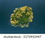Aerial View on a little island and a small boat in the quarry lake Binsfeldsee See at Speyer in Germany.