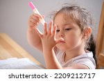 Small photo of Little girl playing iwth invisible ink and coloring book