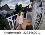 cute young girl in a summer dress playing in a suburban backyarrd