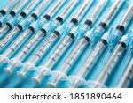 Close up of a group of syringes on a blue table.