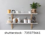Utensils and mugs on shelf