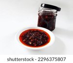 Small photo of Chinese Garlic Chili Oil or minyak cabe in Indonesia made from dried chilies, vegetable oil and other spices. Served in small plate and stored in a jar for longer storage. Isolated on white background