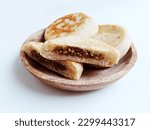 Small photo of Hotteok, South Korean pancakes, fried dough stuffed with nuts and sugar filling, traditional street food. Served on wooden plate and white background.