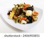 Small photo of Stir Fried Bitter Melon Mushrooms or Oseng Pare Jamur or Tumis Jamur Pare. Chinese food. Made from bitter melon, mushrooms, carrots and eggs. Served on a white plate and isolated on a white background