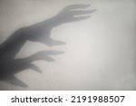 big monster claw shadow on wall. Horror hand shadow on a white background, copy space.