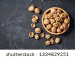 Walnut in wooden bowl on black background with copy space.Top view. Wooden plate with walnut on black background. Space for text