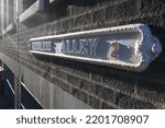 Small photo of Needless alley street sign in setting sun