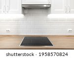 White kitchen with wooden countertop with induction cooktop. Nobody