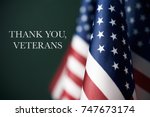 some american flags and the text thank you veterans against a dark green background