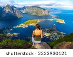  beautiful girl enjoys the panorama of lofoten islands in norway from the famous reinebringen summit; challenging stair climbing; hiking in lofoten islands