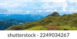 Small photo of A backpacker girl stands on top of Costa Rica's cerro pelado mountains during a sunny day; hiking through mighty mountains covered with green succulent grass; mountains in the tropics amid rainforests