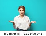 Small photo of What wrong. Ambushed shocked confused young asian girl coworker shrugging hands spread sideways full disbelief asking question questioned perplexed understood situation, blue background.