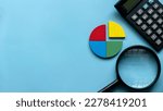 Small photo of Quarterly report concept. Company financial report. Business charts. Colorful quarter wooden pie chart pieces with calculator. Banner with copy space.