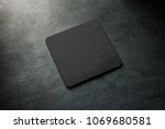 Small photo of Blank black beer coaster mockup lying on grey desk. Square clear dark bar cork table-mat design mock up top side view. Quadrate cup or bottle rug display, isolated.