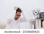 Small photo of Crazy shouting man rending his hair in white shirt, screaming with close eyes and wide open mouth, holding hands on head. Emotions, stress, madness and mental health concept
