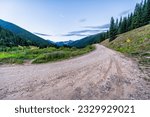 View of green alpine mountains with dirt country rural countryside road to Ophir pass by Columbine lake trail in Silverton, Colorado in summer morning