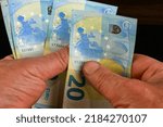 Small photo of Hands several cash twenty euro bills, recalculation banknotes. Parsimony, savings, home finance. Close up.