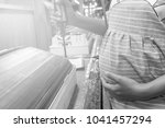 Small photo of Pregnant girl is working hard in the factory. She has the potential to miscarry.