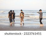 Small photo of garut indonesia 24 mei 2023, four young travelers are walking on the beach , cijeruk beach. there is wahyu, dani, angga, ohim.holiday. 24 mei 2023 , healing