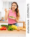 Small photo of Cheerful svelte young woman eating vegetable salad