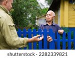 Small photo of Old man talking with his neighbour