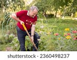 Skilled mature man tending to flower garden