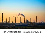 Small photo of Working oil refinery. Smoke from the factory chimney. Ecological pollution. Air emissions polluting the city. Industrial waste is hazardous to health. Large factory in smog, Production in operation.