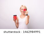 Coffe Woman Lover, Portrait of cheerful young woman holding cup of coffee to go and covering her eye with red heart shape