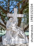 Small photo of Santa Inez, CA, USA - April 3, 2009: San Lorenzo Seminary. Station of the Cross number 13 white marble statue. Jesus taken down from cross. Green foliage in back under blue sky.